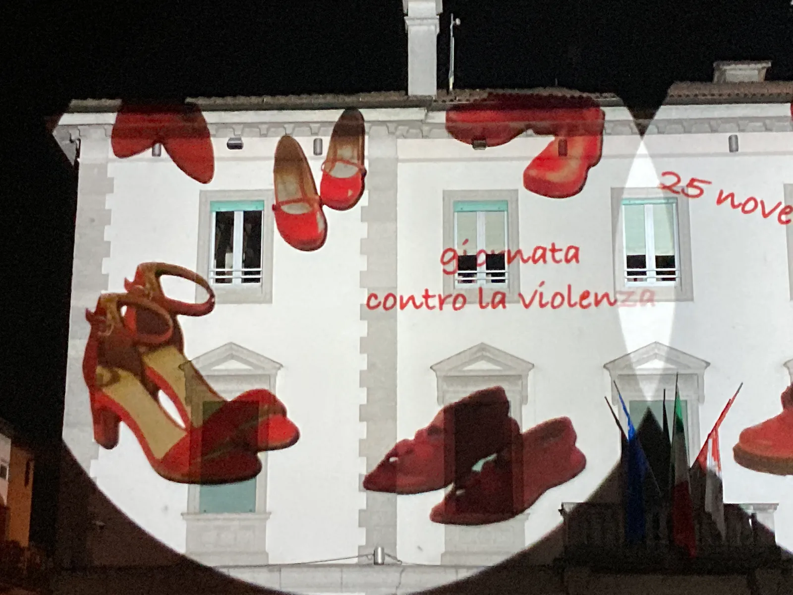 Particolare della proiezione sul municipio di Osio Sotto: scarpe rosse e la scritta giornata contro la violenza, 25 novembre 2021